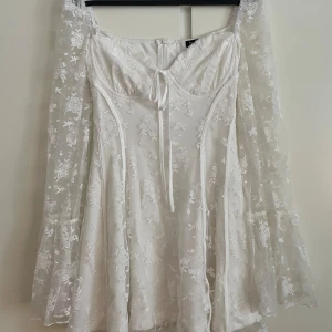 Studentklänning - Vit studentklänning i spets med långa ärmar från Boohoo. Köpt på plick men endast testad av mig då den var för liten. Fint skick, dock har kanten på spetsen släppt litegrann (sista bilden) men ingenting som märks när man har den på. Passar perfekt till studenten/utspringet!