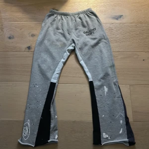 Grå mjukisbyxor från Gallery Dept. - Unika grå mjukisbyxor från Gallery Dept. med konstnärliga färgstänk. Byxorna har en avslappnad passform, perfekt för en kreativ och bekväm stil. Priset är ej hugget i sten, kan sänkas för en snabbaffär