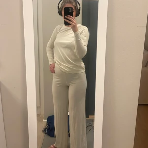 Krämvit ribbad långärmad topp och byxor  - Säljer ett krämvitt ribbat set från Nelly i storlek xs! Har använt max 5 gånger och är i väldigt gott skick. 