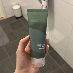 Mugwort Calming Clay Mask - En lugnande lermask med malörtsextrakt från Instree. Förpackningen är grön och innehåller 100 ml produkt. Perfekt för att rengöra och lugna huden. Endast använd 1 gång, och då användes ytterst lite. 