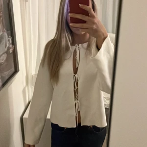 Vit rosett tröja  - Vit lite tjockare tröja med rosetter i mitten, ändrat använd 2 ggr!