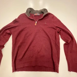 Vinröd merinoulltröja från Morris liten skada på högra arm änden göms när man har på sig den. Storlek Small men krympt i tvätten och passar nu storlek XS - Säljer en stilren vinröd tröja från Morris i 100% merinoull. Tröjan har en dragkedja vid halsen och ribbade muddar. Perfekt för kyligare dagar med sin mjuka och varma känsla.
