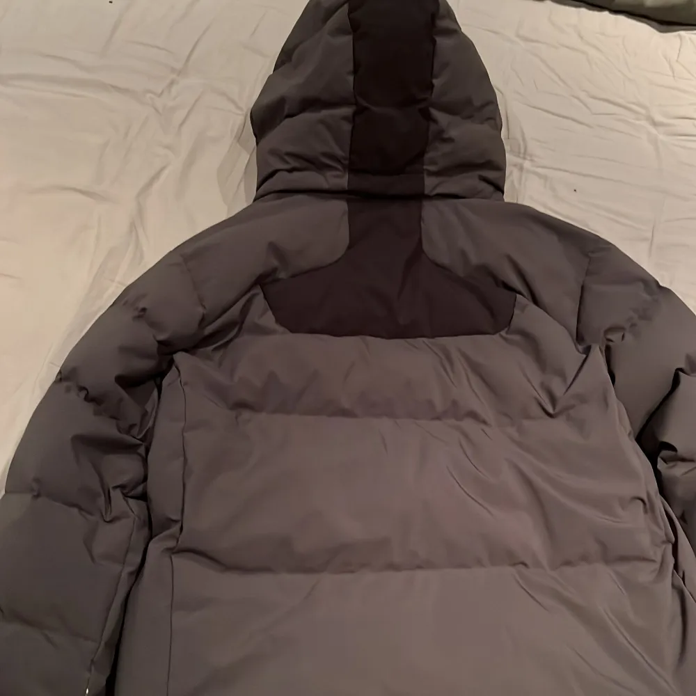Snygg grå vinterjacka från Sail Racing med svart detalj på bröstet . Jackan har en används ett par gångar men är fortfarande i riktigt bra skick.. Takit.