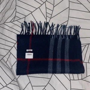 burrberry halsduk!(100% cashmere) - Snygg och lyxig halsduk från Burberry i en klassisk rutig design. Den är tillverkad i 100% kashmir och har en mörkblå bas med röda och grå rutor. Det är kalla tider och den här håller dig varm och bjuder på en stil som fungerar till alla outfits!   ⚠️bundle pris för båda halsdukarna ligger på 1400kr⚠️                                                    var inte rädd att höra av er vid minsta fundering/R.EsellingSWE.