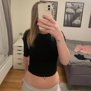 Svart knytbar topp från Cider - Säljer en svart knytbar topp från Cider. Toppen har korta ärmar och är croppad med knytband i midjan. Man kan knyta tröjan lite hur man vill. 