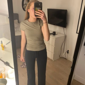 Beige kortärmad topp från H&M - Säljer en stilren beige kortärmad topp från H&M. Toppen har en enkel design och är perfekt för vardagsbruk. Den är tillverkad i ett mjukt och bekvämt material.