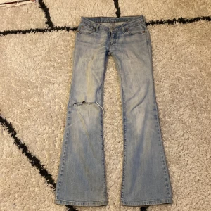 Ljusblå bootcut Levi's jeans - Säljer ett par ljusblå bootcut lågmidjade jeans från Levi's de är lite slitna o har ett hål på ena knät och trasig dragkedja men går att laga, säljer då de är lite för små i midjan midjemått 36cm rakt över, innerbensmått 77cm, säljer endast via Instabox, skriv privat om frågor❤️