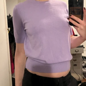 Ljuslila tröja från Zara - Säljer en ljuslila tröja från Zara med korta ärmar och rund hals. Tröjan har en ribbad nederkant och är perfekt för vår och sommar. Passar bra till både jeans och kjol. 🌸