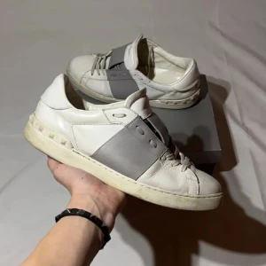 Valentino open - Snygga vita sneakers med grå detaljer från Valentino. Skorna har en stilren design med snörning och en robust sula. Perfekta för en trendig look. Har sänkt priset från 1799 till 999 då jag bara vill få bort dessa, skriv vid intresse så löser vi ett skönt pris 