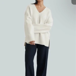 Vit stickad tröja - Säljer en stilren vit stickad tröja med v-ringning och långa ärmar. Tröjan har en loose passform och ribbade detaljer vid ärmslut och nederkant. Perfekt för en avslappnad look. Helt ny med prislapp. Kan tas egna bilder på tröjan skriv pm för frågor💓