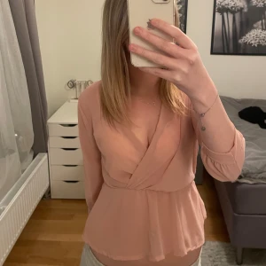 Rosa omlottblus från Boohoo - Säljer en söt rosa omlottblus från Boohoo. Blusen har långa ärmar och en smickrande omlottdesign. Perfekt för en stilren look. 💖