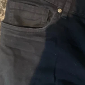 Svarta jeans från H&M - Snygga svarta jeans från H&M i en klassisk stil. De har en normal passform med fem fickor och knappgylf. Perfekta för en stilren look.