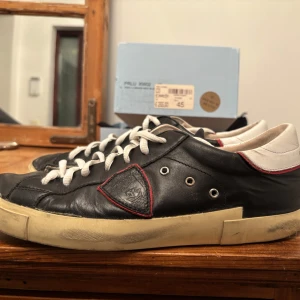 Svarta sneakers från Philippe Model - Snygga svarta sneakers från Philippe Model med röda och vita detaljer, i topp skick. Med box och påse kvar. Svarar snabbt i dm! Pris kan diskuteras