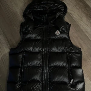 Moncler väst - Snygg svart väst från Moncler. Västen är en Moncler bormes, perfekt för kyliga dagar. Västen är i toppen skick eftersom jag knappt använt den. Skick: 9/10. Pris: 1999kr, priset kan diskuteras såklart!🌟