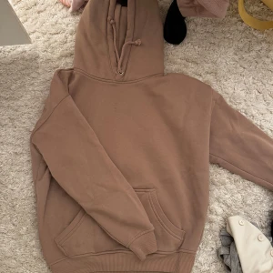 Beige hoodie - Säljer en mysig beige hoodie med känguruficka och justerbar huva. Perfekt för en avslappnad stil.
