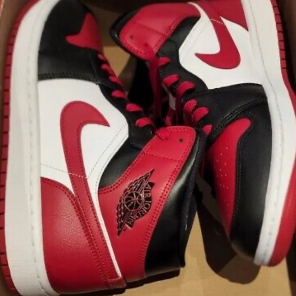 Snygga Nike Air Jordans i en färgkombination av rött, svart och vitt. . Kengät.