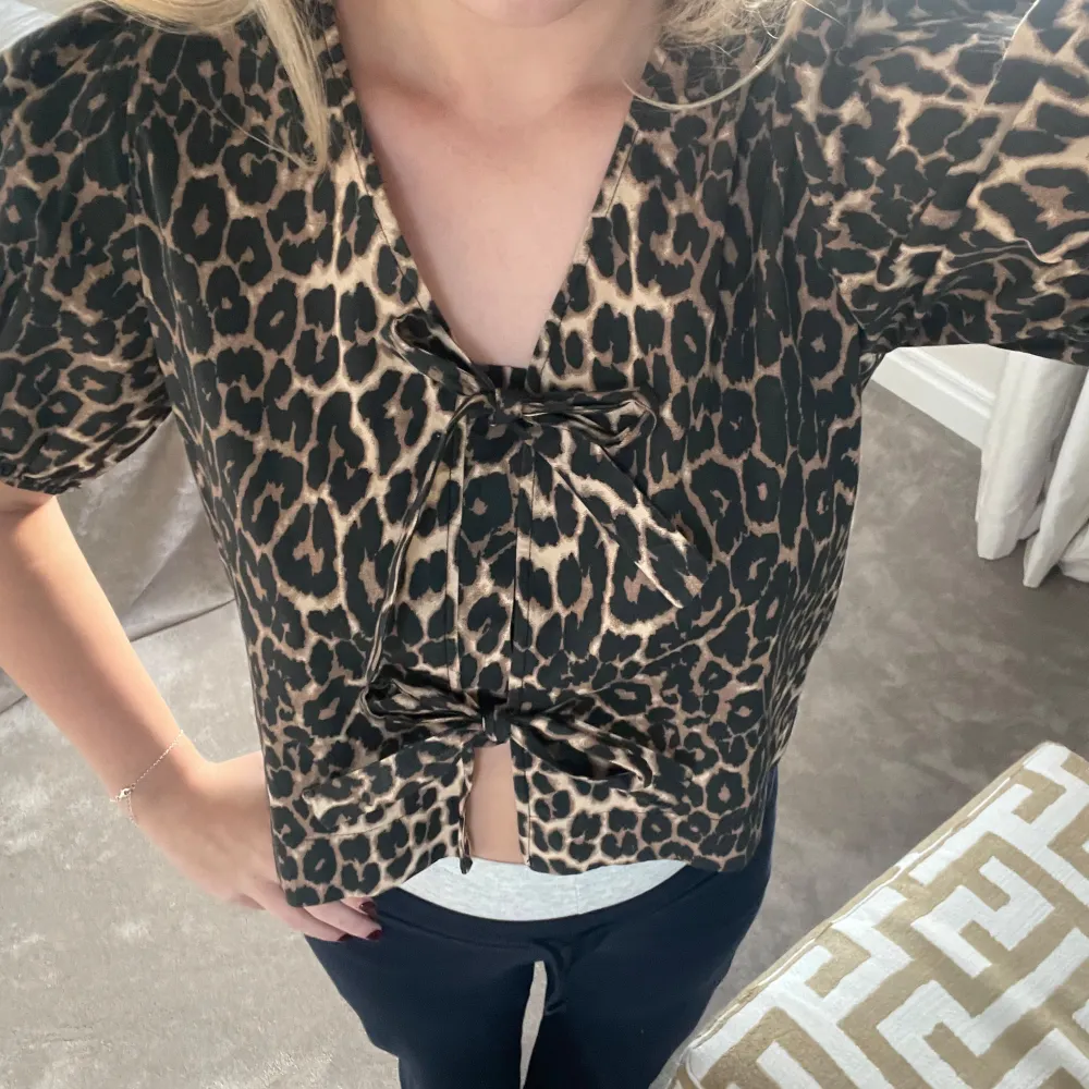 Snygg leopardmönstrad blus från Neo Noir i storlek 36. Blusen har korta puffärmar och knytband framtill för en chic look. Perfekt för både vardag och fest! 🐆✨. Helt ny och köpt för 599. Toppar.