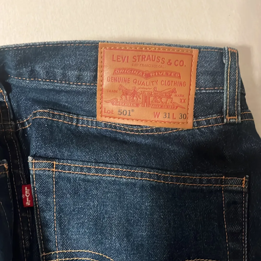 Säljer ett par klassiska Levi's 501 jeans i mörkblå denim. De har en rak passform och är i mycket bra skick. Perfekta för både vardag och fest!. Jeans & Byxor.