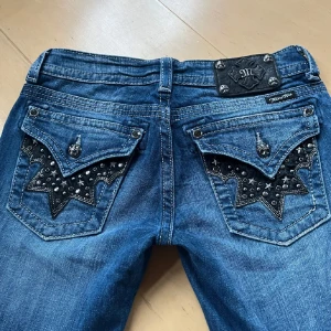 Miss Me Jeans - Snygga blå jeans från Miss Me med unika stjärndetaljer och nitar på bakfickorna. De har en låg midja är flare ❣️ Bilderna är lånade från förra ägaren så hör av dig vid frågor eller egna bilder!!❣️innerbenslängd: 88 midjemått: 82,5 (w27)