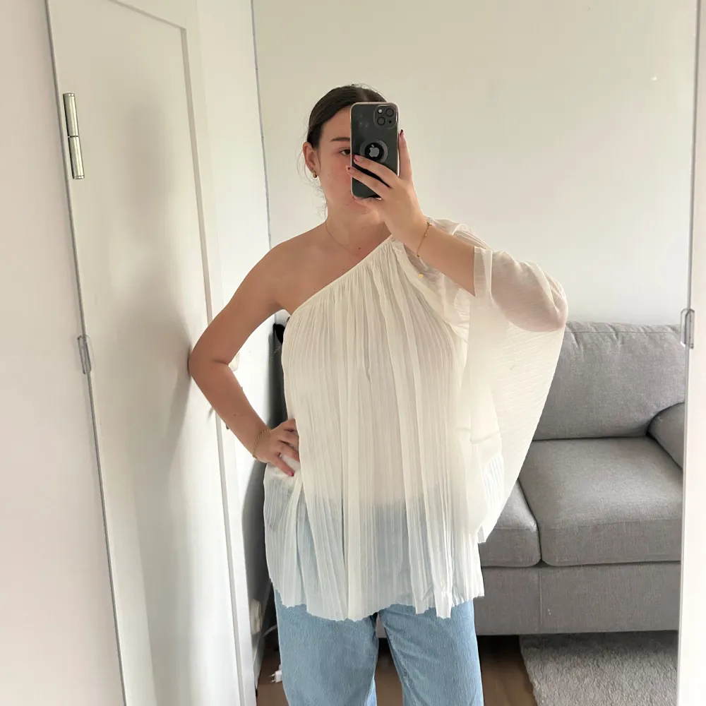 Väldigt fin elegant och flowy blus, one shoulder. Genomskinlig så sitter ett ”linne” fast under. Knappt använd. Blusar.