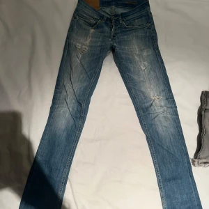 Blå jeans från Dondup - Säljer ett par snygga blå jeans från George i skinny fit. De har en cool slitning på låren och knäna som ger en avslappnad look. Perfekta för både vardag och fest! De är i bra skick och redo för en ny ägare.