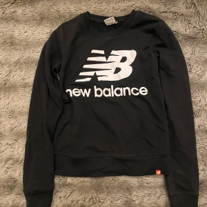 Svart tränings tröja - Säljer en svart tränings tröja i mycket bra skick. Den har en stor logga på framsidan och är perfekt för både vardag och träning. Tröjan är långärmad och gjord i ett mjukt material som känns skönt mot huden.