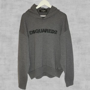 Grå Stickad Hoddie från DSQUARED2 - Tjock stickad hoddie från Dsquared2 i nyskick! Storlek XL ungdom som passar S-M herrstorlek.