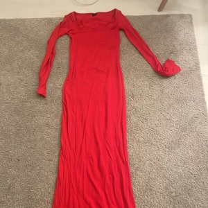Röd långklänning - Säljer en snygg röd långklänning i mycket bra skick. Klänningen har en tight passform och är långärmad, perfekt för höst och vinter. Den är gjord i ett mjukt och stretchigt material som sitter bekvämt på kroppen. Perfekt för festliga tillfällen eller en utekväll!