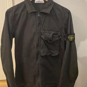 Stone Island overshirt - Stilig stone Island overshirt💫 den är i rätt så bra skick. 7-10. Den har tappat lite färg runt fickan och den har ett väldigt litet hål i armhålan som inte syns när den bärs. Hör gärna av er vid frågar eller minsta lilla🙌