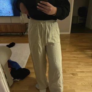 Beige linnebyxor från NA-KD - Säljer ett par superbekväma beige linnebyxor från NA-KD i storlek 36. De har en loose passform med elastisk midja för extra komfort.