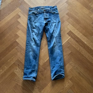 Blå jeans från Nudie Jeans - Säljer ett par snygga blå jeans från Nudie Jeans i storlek 30/32. De har en klassisk femficksdesign och är i bra skick. Perfekta för både vardag och fest! 🕺