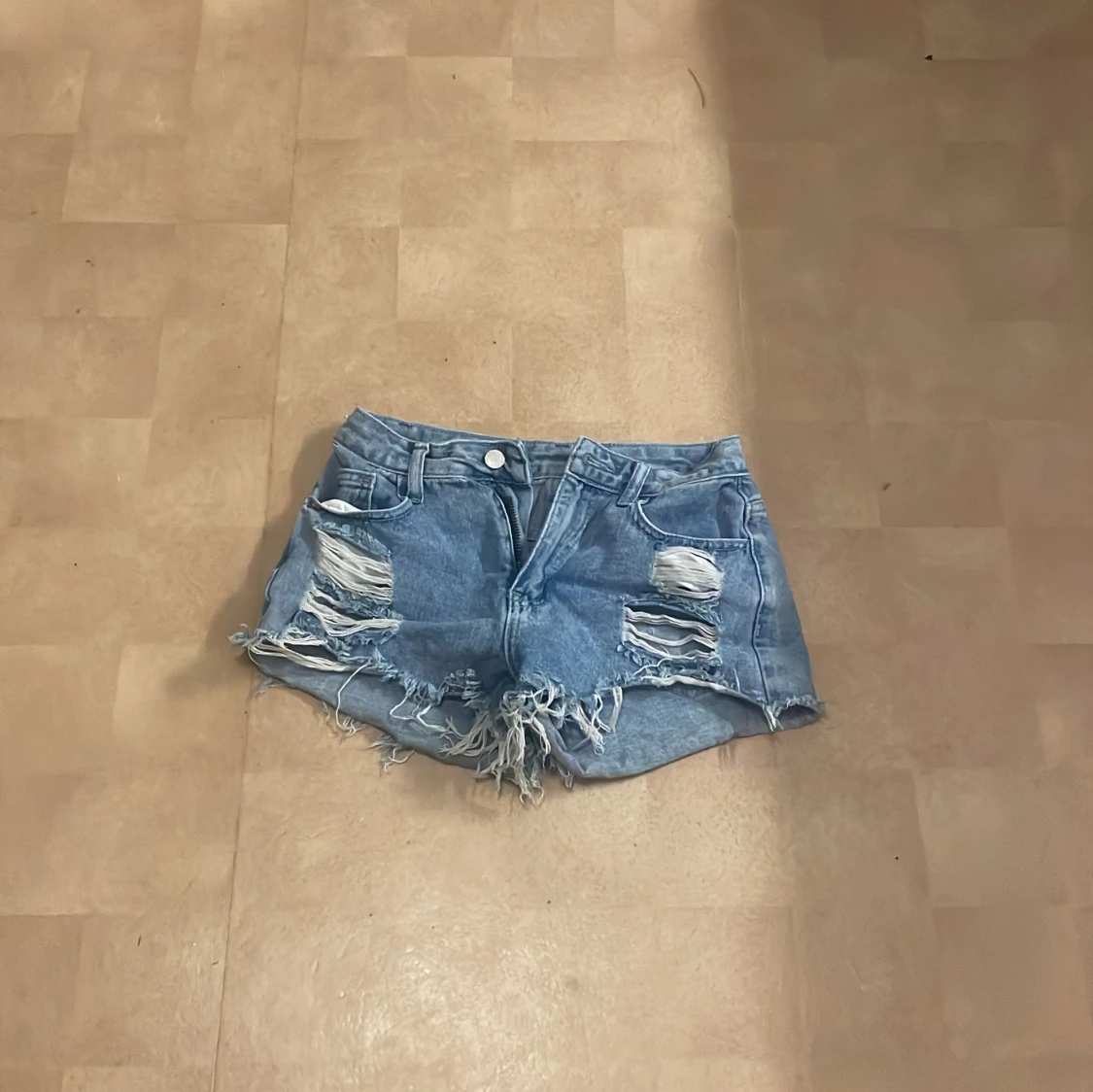 Blå jeansshorts med slitningar