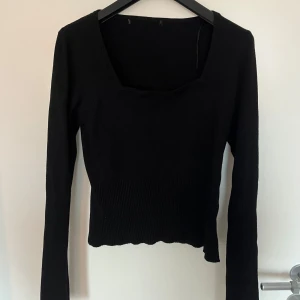 Svart långärmad topp - Säljer en stilren svart långärmad topp med fyrkantig halsringning. Den är ribbad . Perfekt för både vardag och fest! 🖤