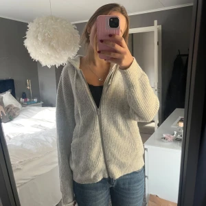Stickad kofta med dragkedja - Mysig grå stickad kofta med dragkedja framtill. Perfekt nu till hösten! Koftan har en avslappnad passform. Supermysig och skön!