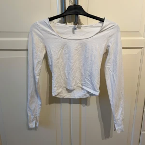 Vit långärmad topp från Divided - Säljer en vit långärmad topp från Divided i storlek S. Den är croppad och har en enkel design.  Materialet är mjukt och bekvämt. 