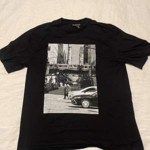 Säljer en svart t-shirt från H&M i storlek M. Den har ett svartvitt tryck av New york. Perfekt för en avslappnad stil med sin relaxed fit. Passar bra till det mesta