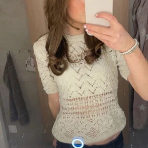 Beige stickad topp - Säljer en superfin beige stickad topp med ett snyggt hålmönster. Toppen är både stilren och lätt att matcha med olika outfits. Perfekt för både vardag och fest!🩷