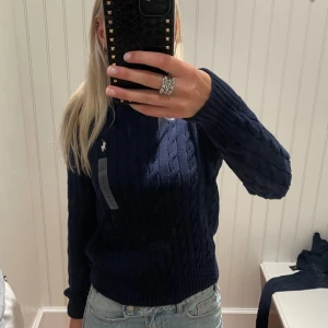 Ralph lauren tröja  - Använd endast en gång, köpte för 2600kr så säljer för väldigt bra pris. Jätte fin kabelstickad tröja som ser ut exakt som ny. Fin passform och är sann i storlek. Äkta. 