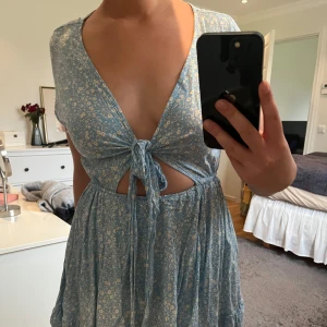 Blå klänning  - Somrig klänning med knytband fram. En söm har spruckit lite grann vid banden, inget som stör. 