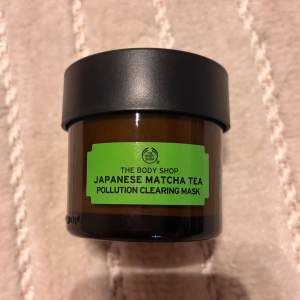 Säljer en Japanese Matcha Tea Pollution Clearing Mask från The Body Shop. Den kommer i en snygg brun glasburk med svart lock. Perfekt för att rengöra huden från föroreningar och ge en fräsch känsla. Används för att återfukta och rena huden. Perfekt för en spa-dag hemma! Köpt för 199kr från början och är oanvänd 