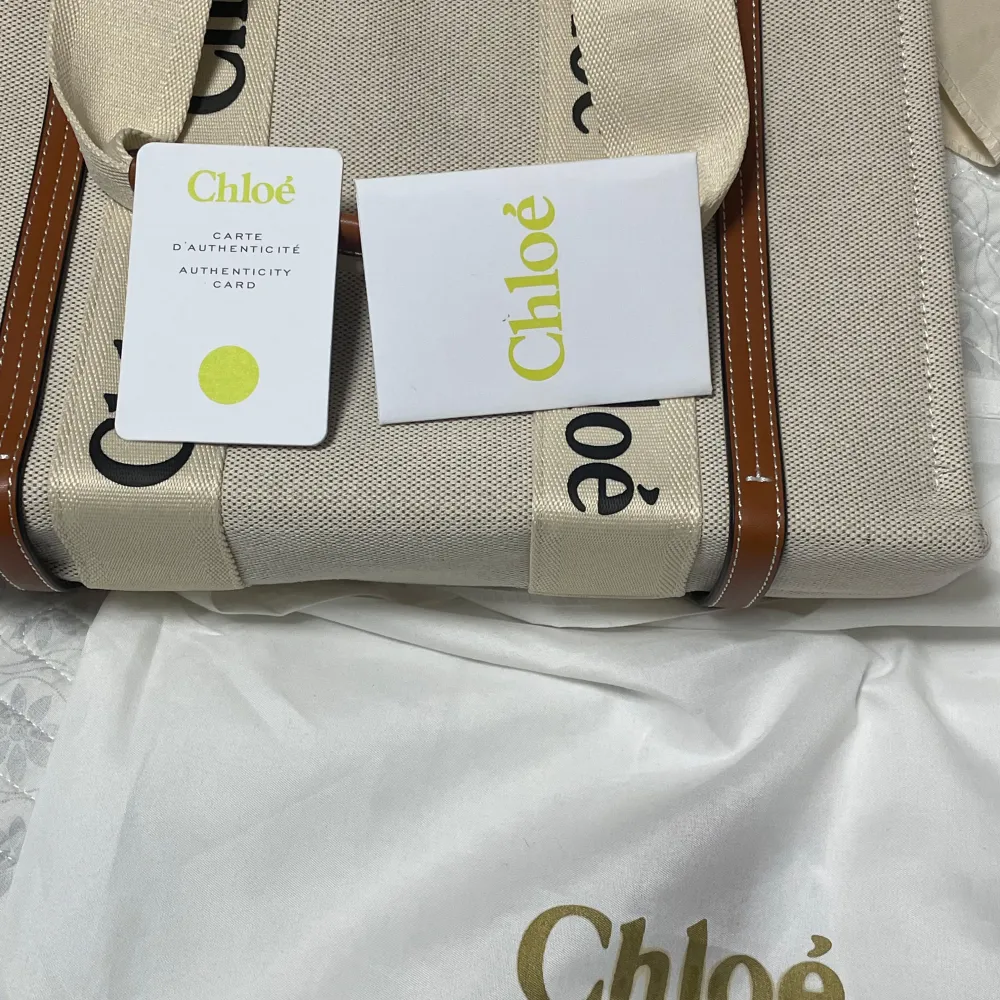 Säljer en snygg beige shoppingväska från Chloé i mycket bra skick. Väskan är gjord av slitstarkt material med bruna detaljer och har Chloé-loggan tryckt på handtagen. Perfekt för både vardag och shoppingrundor. Kommer med äkthetskort och dustbag. Pris går att diskutera. Väskor.