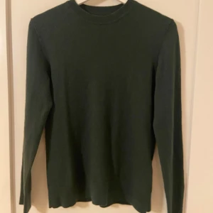 Grön tröja från Samsøe Samsøe - Säljer en stilren och bekväm grön tröja från Samsøe Samsøe i färgen 'Deep Forest'. Nypris ca 900kr, Mitt pris 349kr. Tröjan har en klassisk rund hals och långa ärmar, perfekt för både vardag och lite finare tillfällen. Den är i mycket bra skick och passar perfekt till höst- och vårgarderoben.