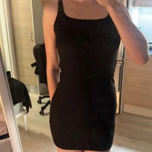 Svart ribbad klänning stl S H&M - Säljer en kort, svart ribbad klänning i mycket bra skick. Den är ärmlös och har en tight passform. Den är aldrig använd då den är liiiite för kort på mig som är 176. Har en i M också med prislappen kvar!