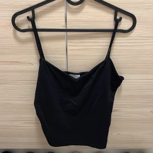 Svart linnetopp från Clothes stl L - Snygg svart linnetopp från Clothes i storlek L. Perfekt för sommardagar eller som ett basplagg. Den har smala axelband som inte går att justera. Bra skick