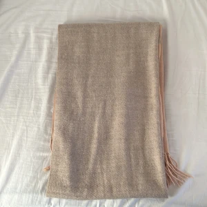 Beige halsduk - En varm, skön, tvåfärgad halsduk från Anna Field som säljs då den inte längre kommer till användning. Vid intresse tveka inte att kontakta mig för fler bilder!