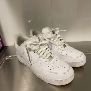 Vita Nike Air Force  - Säljer ett par klassiska vita Nike Air Force  i bra skick. De har en stilren design med snörning och är perfekta för vardagsbruk. Skorna är i storlek herr 42 och passar till alla tillfällen. Perfekta för dig som vill ha en tidlös stil!