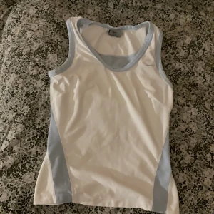 Nike linne  - Snyggt o sportigt Nike linne. De ljus blå ”linjerna” är av nät material för att linnet ska kunna andas bättre. Är av stretchigt material och formar sig efter kroppen. Slutar på magen. Skriv om frågor fler bilder ❤️