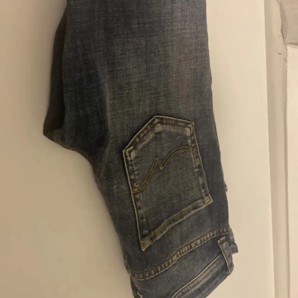 Säljer ett par snygga blå jeans från Jack & Jones i storlek 146. De har en slim passform och är i bra skick med coola slitningar på framsidan. Perfekta för både vardag och fest! 🕺. Farkut & Housut.