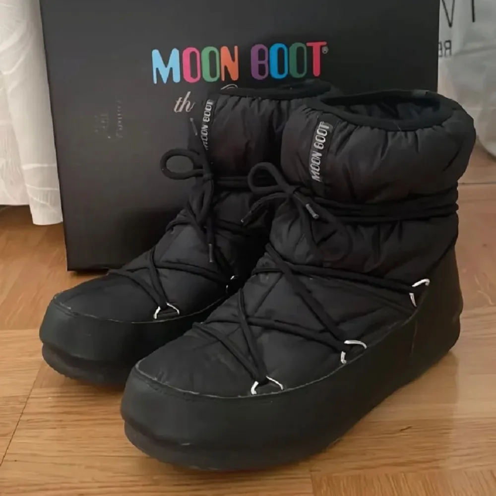 Säljer ett par svarta Moon Boots i mycket bra skick. De är perfekta för vintern med sitt varma och vadderade material. Skorna har snörning och en robust sula som ger bra grepp på snöiga underlag. Perfekta för kalla dagar! Tror de heter moon boot low nylon wp 2. Svarta i storlek 40. Köpta från en annan på Vinted. Då hade de använts två gånger. Jag har använt de en gång med de är för små för mig tyvärr. Skorna har med en extra sula som är lite varmare. Men är överlag en perfekt vintersko!!. Kengät.