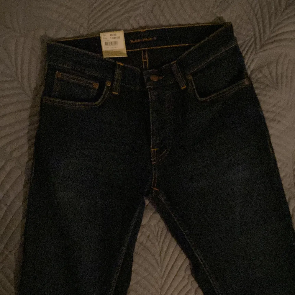 Säljer ett par snygga mörkblå jeans från Nudie  (model GRIM TIM). De är aldrig använda lapparna sitter kvar. Jeansen har en klassisk slim fit design stl  W29 L32. Perfekta för både vardag och fest!. Jeans & Byxor.